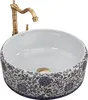 A white ceramic sink with a blue floral pattern and a gold faucet. Anteprima dell’immagine prodotto