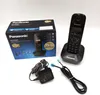 A Panasonic cordless phone and its accessories are laid out on a white surface, with the product box in the background. Podgląd zdjęcia produktu