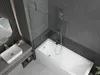 A modern bathroom with a bathtub, shower screen, and sink. Náhled obrázku produktu