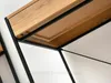 Close-up view of the underside of a wooden desk with a black metal frame. Náhled obrázku produktu