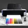 A printer is printing a color calibration chart, with a bottle of ink next to it. Produktbild-Vorschau