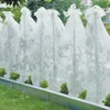 Plants covered with protective fleece in a garden setting. Produktbild-Vorschau