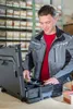 A man is sorting through a toolbox in a warehouse. Podgląd zdjęcia produktu