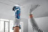 A person is using a Bosch cordless multi-cutter to cut a square opening in a ceiling. Podgląd zdjęcia produktu