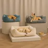 Three dogs are resting in different colored dog beds, arranged on pedestals against a neutral background. Produktbild-Vorschau
