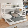 A white bunk bed with a pull-out trundle bed, set up in a room with a desk and shelves in the background. Náhled obrázku produktu