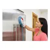 A woman is cleaning a stainless steel refrigerator with a handheld steam cleaner. Voir les images du produit