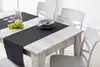 A dining table set with chairs, a table runner, grapes, and place settings. Anteprima dell’immagine prodotto
