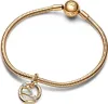 A close-up studio shot of a gold Pandora bracelet with a zodiac constellation charm. Voir les images du produit