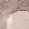 A close-up view of a fluffy rug with a curved edge. Voir les images du produit