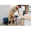 A man is using a planer on a wooden surface in a workshop or kitchen setting. Anteprima dell’immagine prodotto