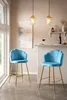 Two blue bar stools with gold legs are placed in a modern kitchen or dining area. Produktbild-Vorschau