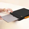 A person is inserting a laptop into a black laptop sleeve with a brown handle. Náhled obrázku produktu