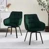 Two green velvet dining chairs with black metal legs are shown in a room setting. Voir les images du produit