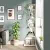 A corner bookshelf with decorative items and artwork on a wall. Podgląd zdjęcia produktu