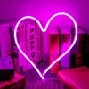 A neon heart light is displayed in front of a shelf of books, with some books in the foreground. Anteprima dell’immagine prodotto