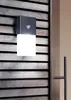 A modern outdoor wall light with a motion sensor is mounted on a slatted wooden wall. Produktbild-Vorschau