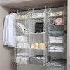 Weißer hängender Kleiderschrank-Organizer aus Kunststoff mit mehreren Gitterablagen, gefüllt mit Kleidung, Büchern und einer Handtasche in einem Kleiderschrank Anteprima dell’immagine prodotto