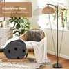 A floor lamp is placed next to a chair in a living room setting. Podgląd zdjęcia produktu