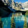 A serene mountain lake with snow-capped peaks and pine trees in the foreground. Produktbild-Vorschau