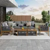 An outdoor patio set with a sofa, chairs, and coffee tables, set against a backdrop of trees and a cloudy sky. Voir les images du produit