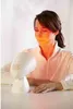 A woman is using a facial infrared lamp. Produktbild-Vorschau