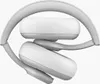 A pair of white headphones folded and resting on a white background. Produktbild-Vorschau
