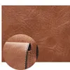 A close-up view of the texture and stitching of a brown leather bag. Produktbild-Vorschau