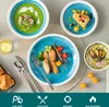A table setting with various dishes and tableware, including soup, fish, salad, and dessert. Produktbild-Vorschau