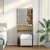 A vanity table with LED lights and a stool in a bedroom setting. Voir les images du produit