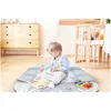A young child is playing on a mat with toys in a nursery. Anteprima dell’immagine prodotto