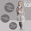 A woman wearing a grey hooded blanket, with text overlays describing product features. Produktbild-Vorschau