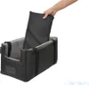A hand is placing a dark gray insert into a black dog car seat. Produktbild-Vorschau
