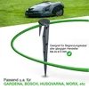 A robotic lawnmower is in the background, and a green boundary wire is held in place by a black stake in the foreground. Produktbild-Vorschau