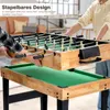 Two people are shown assembling or demonstrating a multi-game table, with one person lifting the foosball table component off the pool table component. Podgląd zdjęcia produktu