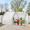 A mini greenhouse filled with potted plants on a wooden deck. Produktbild-Vorschau