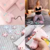 A collage of images showing a sewing tool for attaching buttons and decorative elements to fabric, with a woman using it in a bedroom setting and close-ups of the tool and accessories. Produktbild-Vorschau