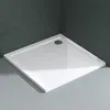 A white square shower tray with a silver drain is placed in a corner of a bathroom with dark gray tiled walls and light gray tiled floor. Produktbild-Vorschau