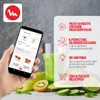 A hand holding a smartphone displaying a recipe app, with a blender and fresh ingredients in the background. Voir les images du produit