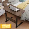 A portable table with a laptop, phone, and watch on it, placed next to a bed. Anteprima dell’immagine prodotto