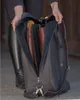 A person is packing boots into a bag. Produktbild-Vorschau