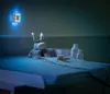 A nursery changing table at night with a stuffed donkey, baby care items, and a night light. Voir les images du produit