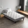 A bedroom scene with a mattress and bed frame. Voir les images du produit