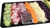 A black tray filled with various sliced vegetables, including cucumbers, radishes, red onions, carrots, white cabbage, and red cabbage. A metal mandoline slicer is placed in the center. Produktbild-Vorschau