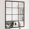 A mirror reflecting a living room scene with a sofa and plants. Náhled obrázku produktu
