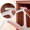 A close-up view of a white plastic bracket attached to a wooden surface, with an arrow pointing to a similar bracket on a wooden shelf. Produktbild-Vorschau