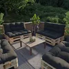 An outdoor patio set with pallet furniture and dark cushions, surrounded by greenery. Anteprima dell’immagine prodotto