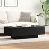 A black coffee table in a living room setting with a sofa and a plant. Produktbild-Vorschau