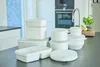 A collection of white plastic food storage containers with transparent lids arranged on a dark countertop in a kitchen setting. Produktbild-Vorschau