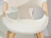 Close-up of a cream-colored, textured chair seat with curved wooden armrests. Produktbild-Vorschau